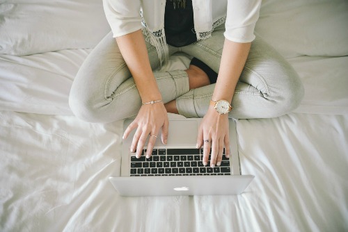 Wonans-Hands-With-Jewelry1-Typing-On-Laptop-Sitting-On-A-Bed