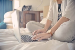 female typing website content sitting cross legged